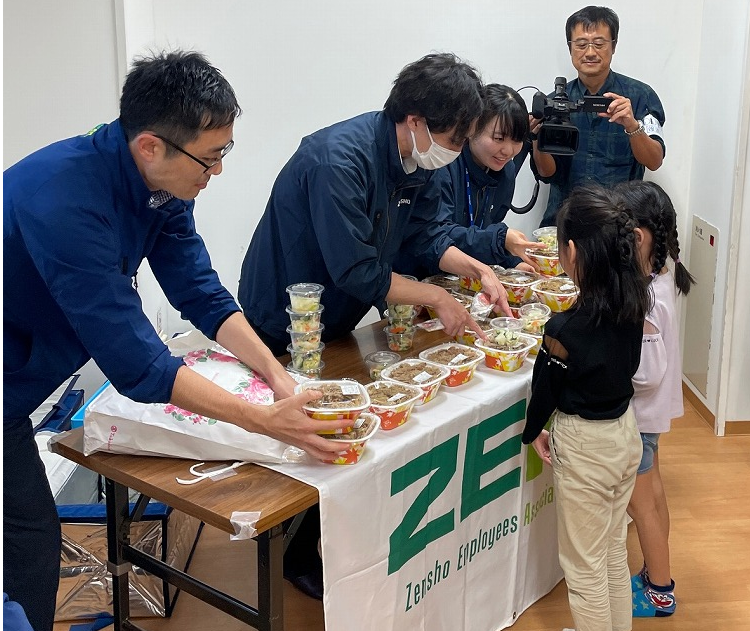 zeanの方が子どもたちにすき家の牛丼を渡している写真
