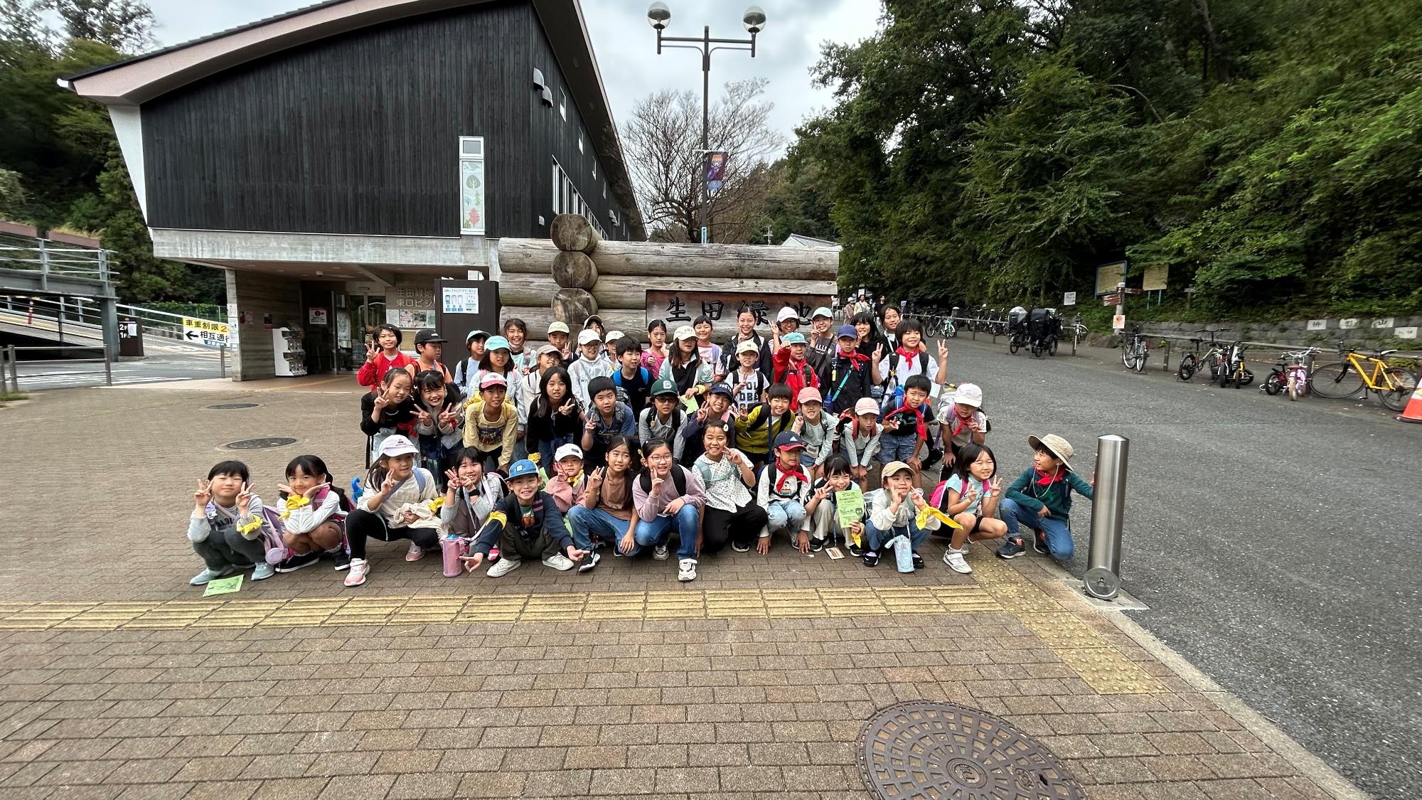 入口で全員集合の記念写真を撮る子どもたちの写真
