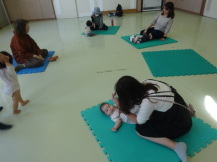 こちょこちょをしてもらって喜ぶ乳幼児の写真