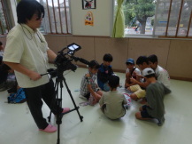 取材用カメラが回っていて、緊張している子どもの写真