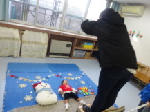 クリスマスをテーマにした背景に寝た赤ちゃんの写真を撮影するお母さん