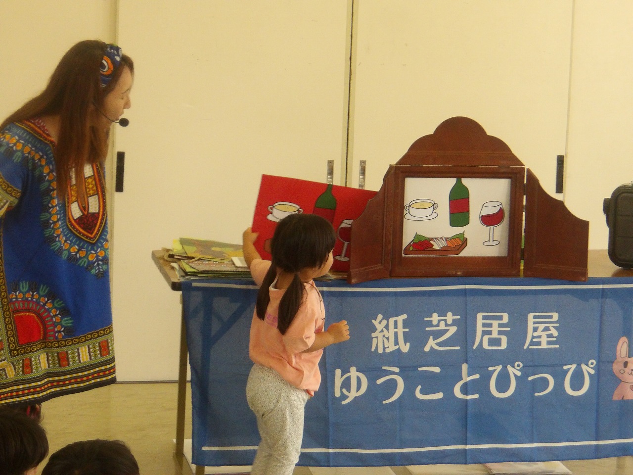 紙芝居を聞く乳幼児親子の写真