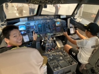 飛行機の操縦席を体験する小学生児童の写真