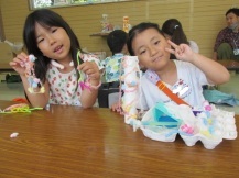女の子が2人で出来上がった作品を見せながらポーズをとっている写真