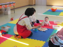はいはいしながらおもちゃを見ている赤ちゃんの写真