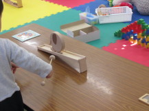 幼い子が木の象のおもちゃで遊んでいる写真