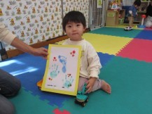 完成した自分の作品を男の子がカメラに見せている写真