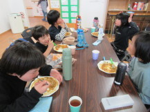 掃除の後にカレーライスとフルーチェを食べている子供の写真