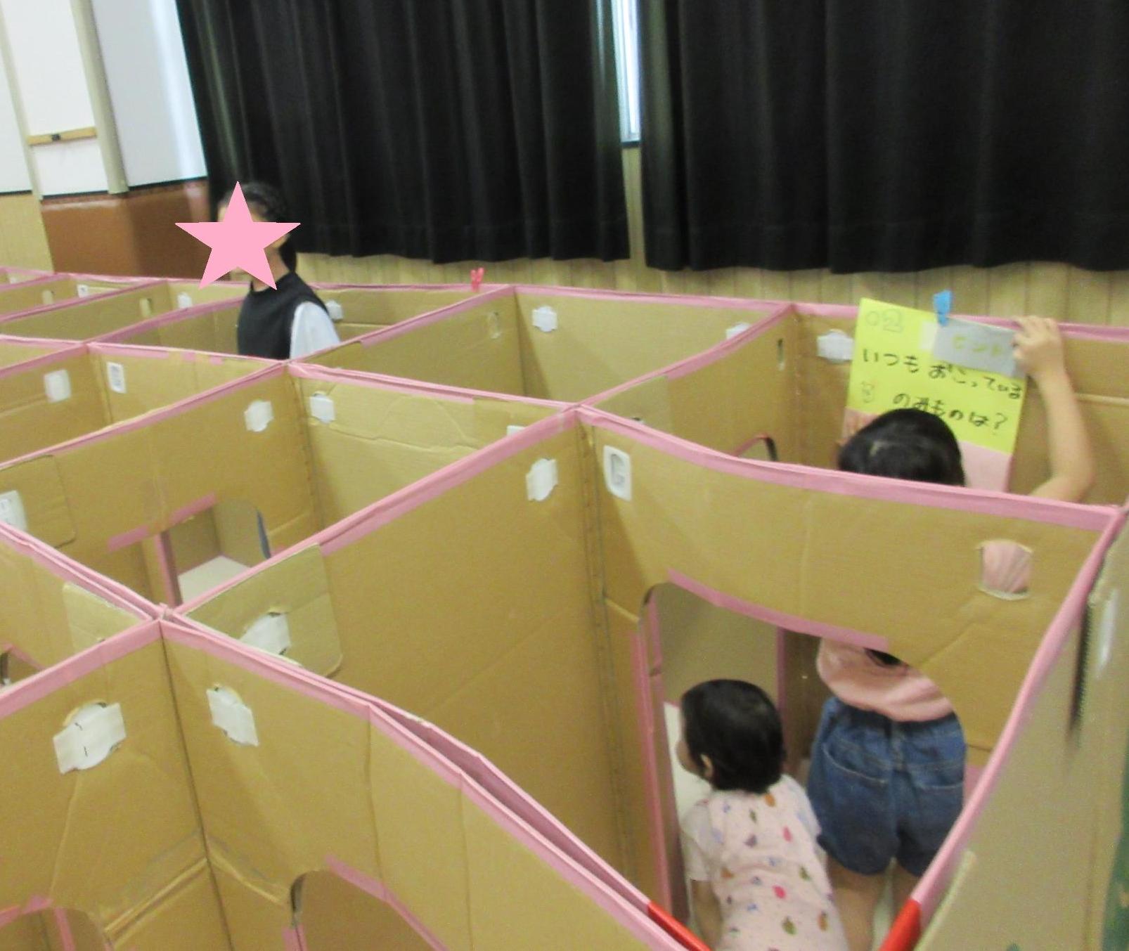 めいろでクイズにを見つけて問題を読んでいる子どもとこっちに進もうかと考えている子どもと立ち上がって様子を見る子ども
