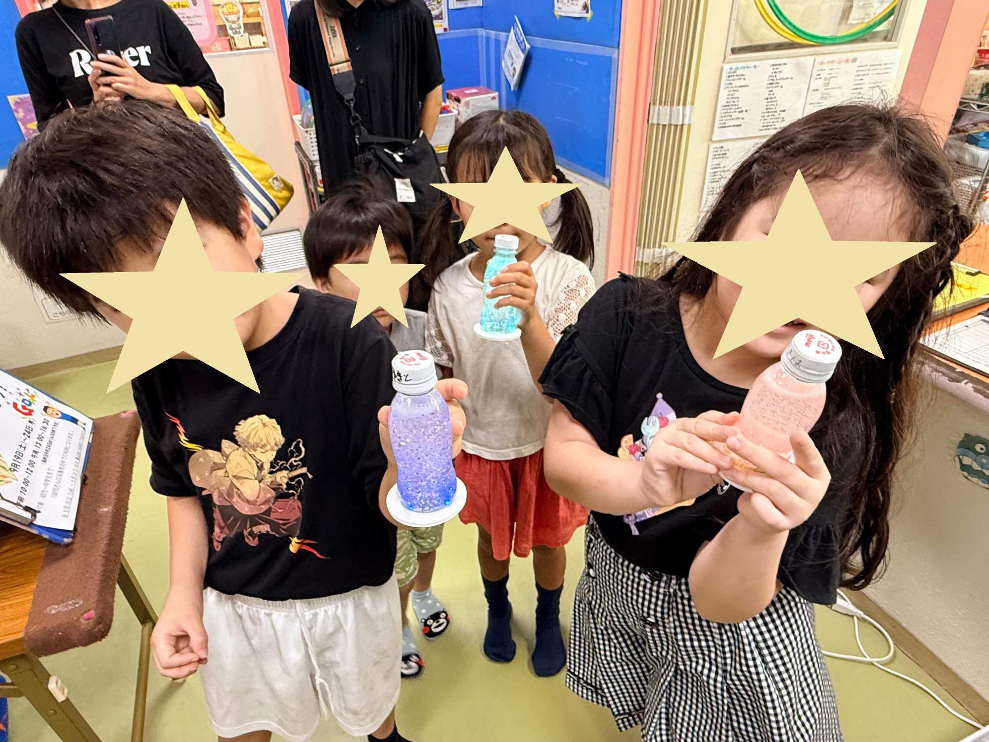自分の作ったランタンに灯をつけ赤や青や緑に輝かせて持っている子どもたち