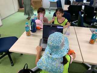 児童が、大学生が自作したゲームを体験している様子の写真