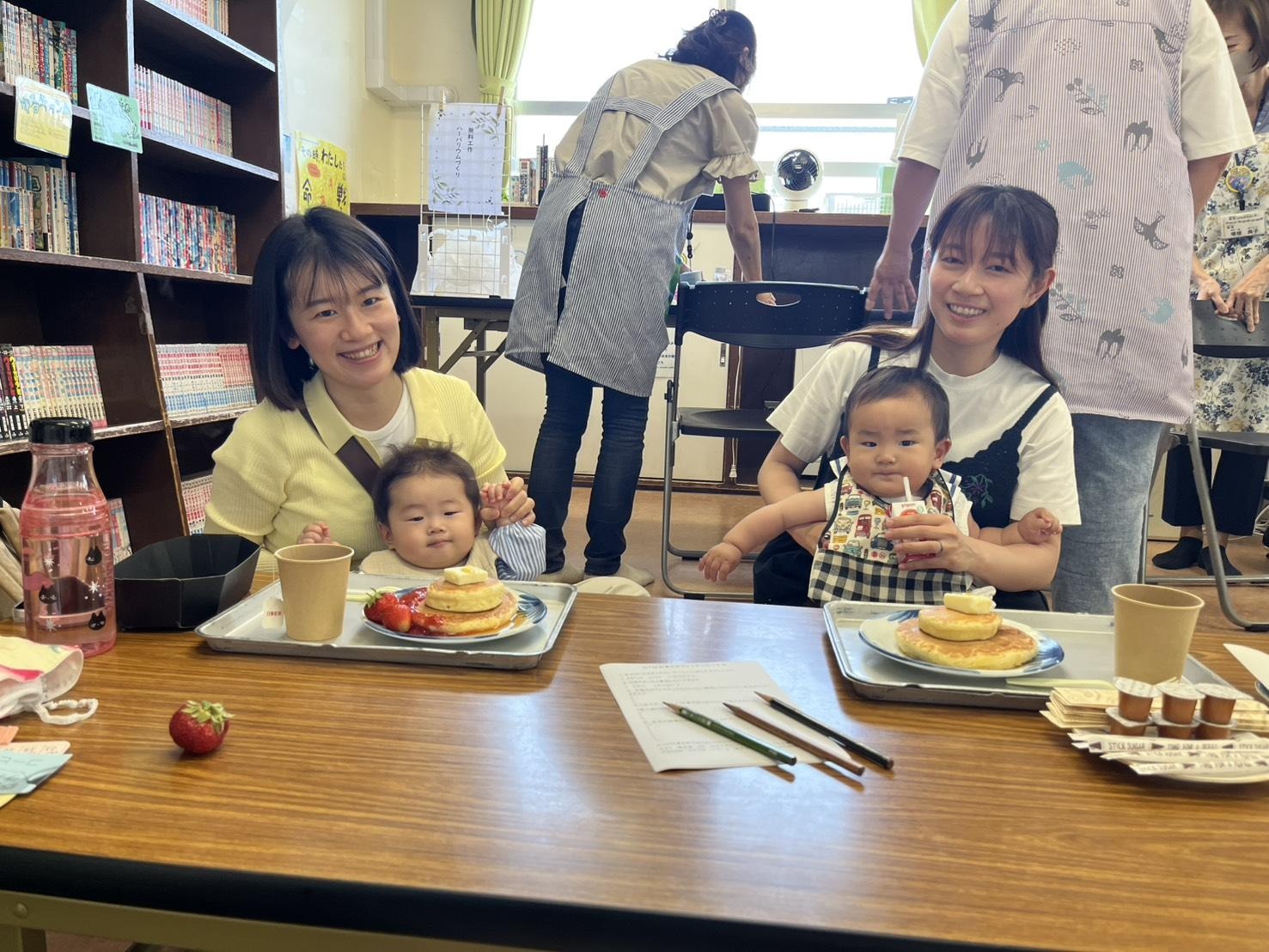 カフェ行事でホットケーキを食べようとしている乳幼児親子の写真