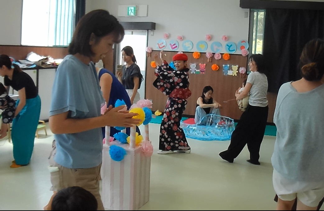 やぐらを囲んで幼児親子が踊っている写真