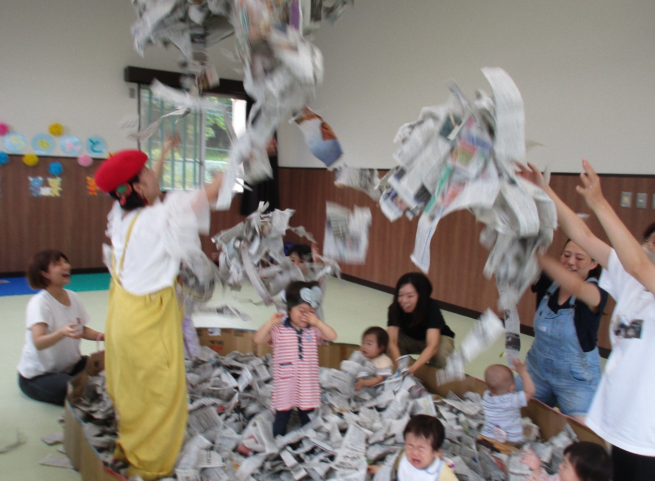 ビビちゃんとで、乳幼児親子が新聞紙遊びをしている写真