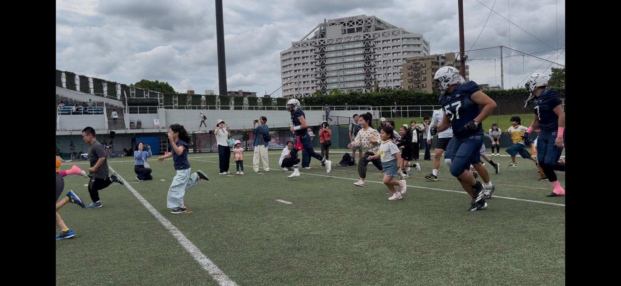 子どもたちがシルバースターの選手と一緒に選手入場を行う写真