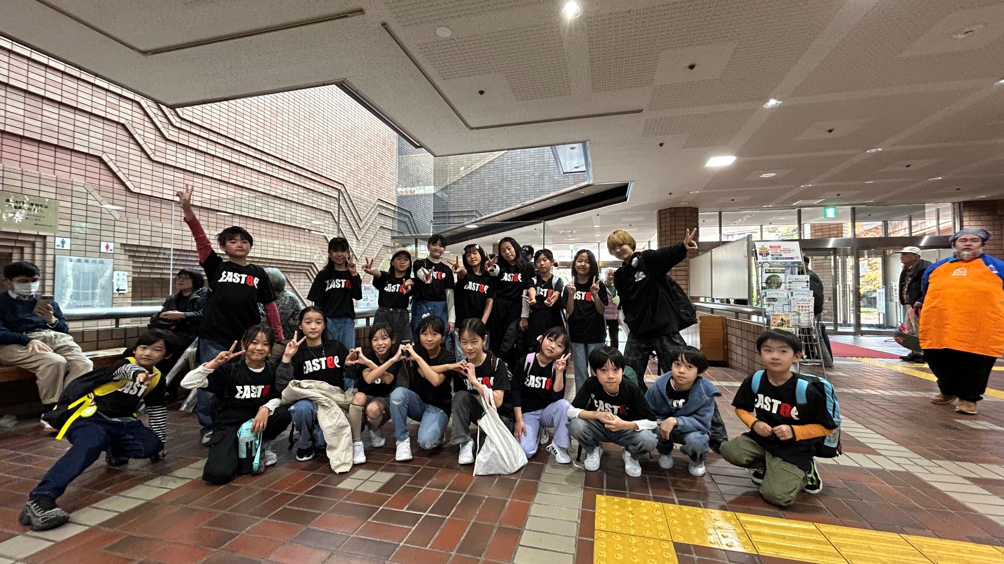 ステージでの発表を終えて、ホールの前で記念撮影をするイーストップの子ども達の写真