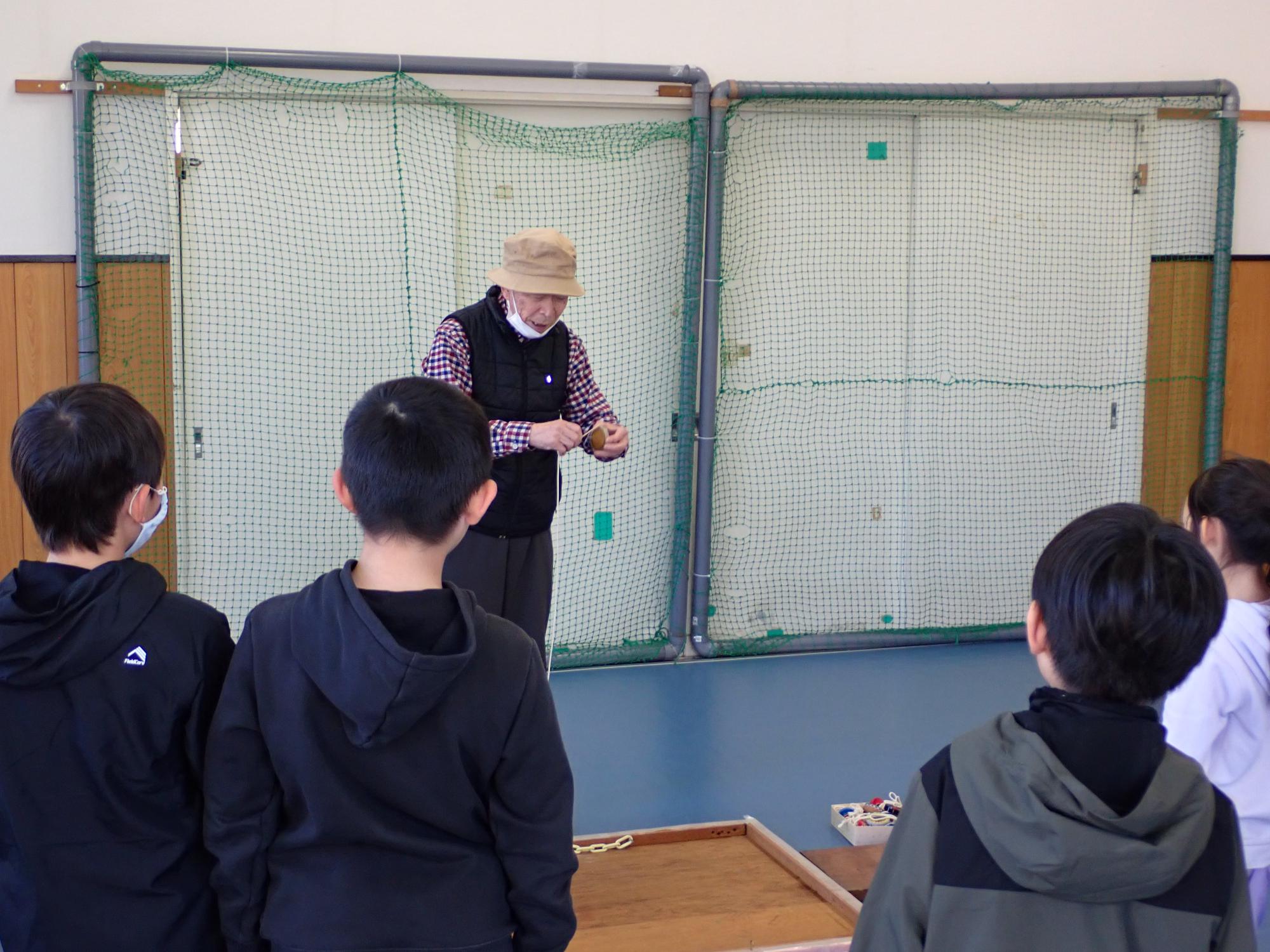 コマの回しかたを地域の方が教えてくれている様子