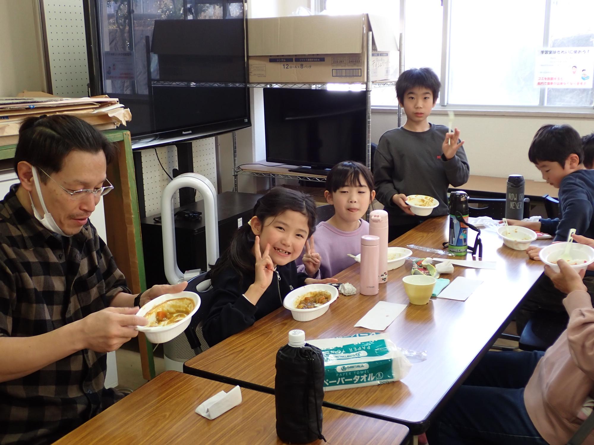 手作りのカレーをみんなで食べている様子