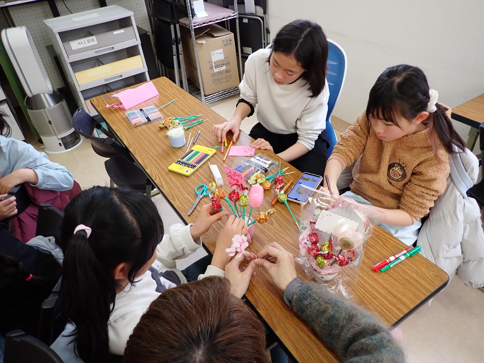 チョコや飾りをつかってブーケを作っている様子（飾りを紙のテープで巻いている）