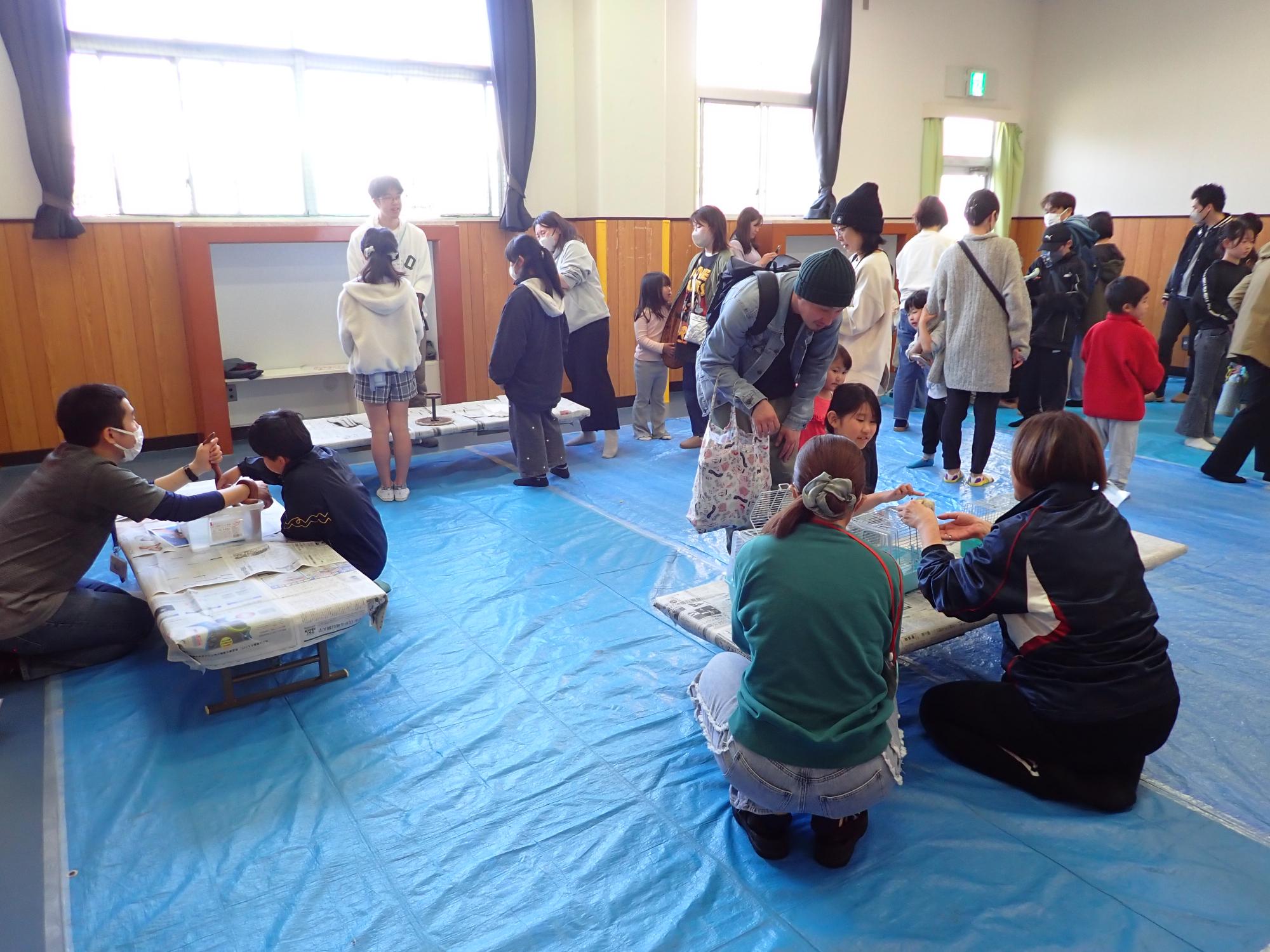 集会室で動物がいるコーナーに参加者が回っている様子