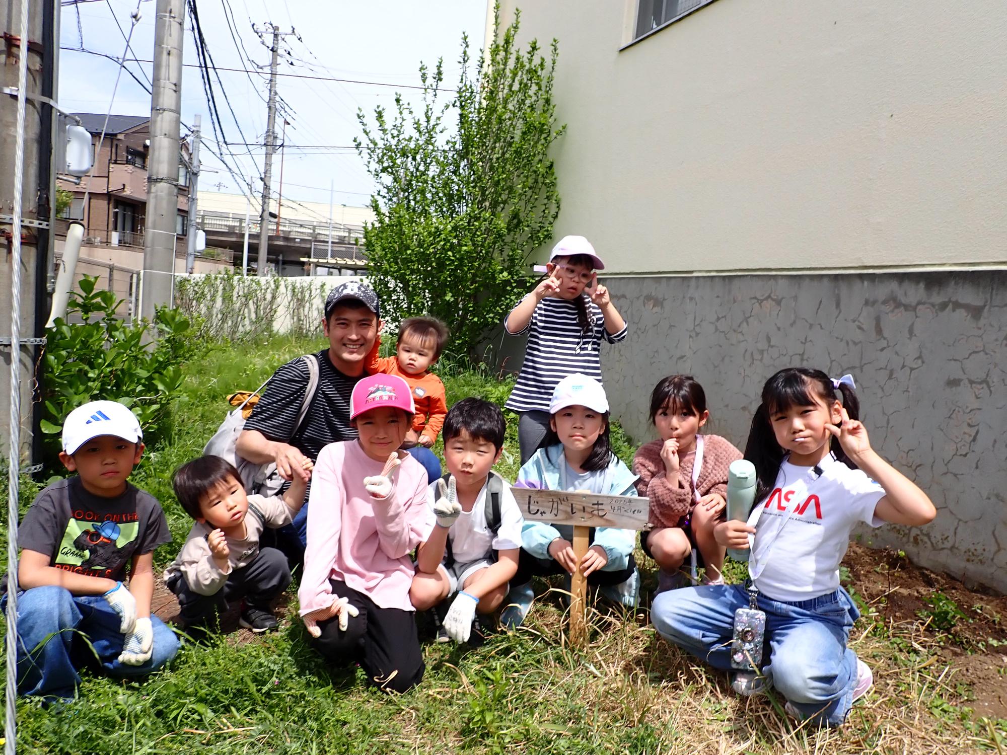 じゃがいもの看板を囲んで、記念写真を撮る子どもたちの写真