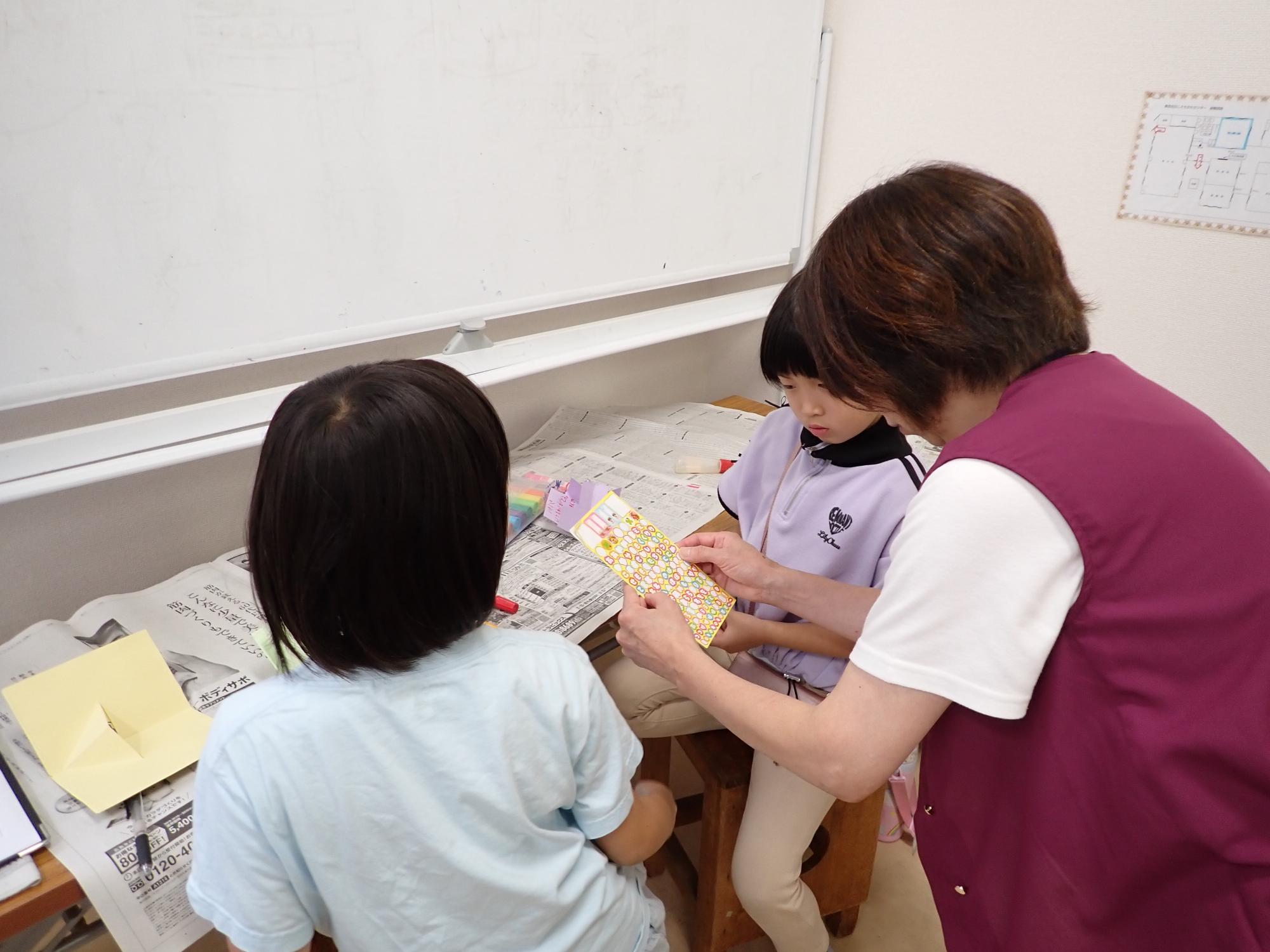 装飾をどうするか職員と相談する子どもの写真