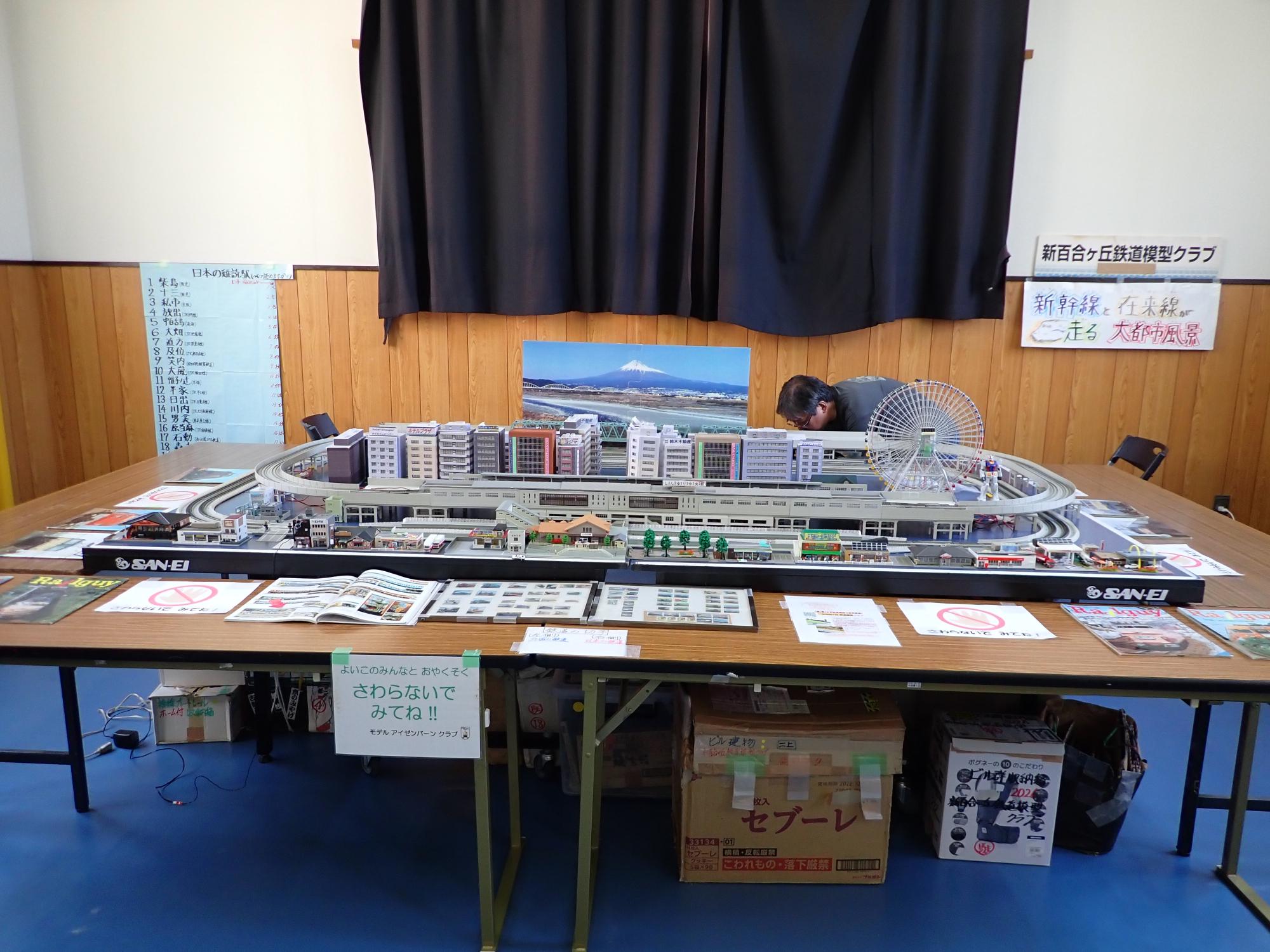 街のジオラマとその中を走る鉄道模型の展示準備をしている写真