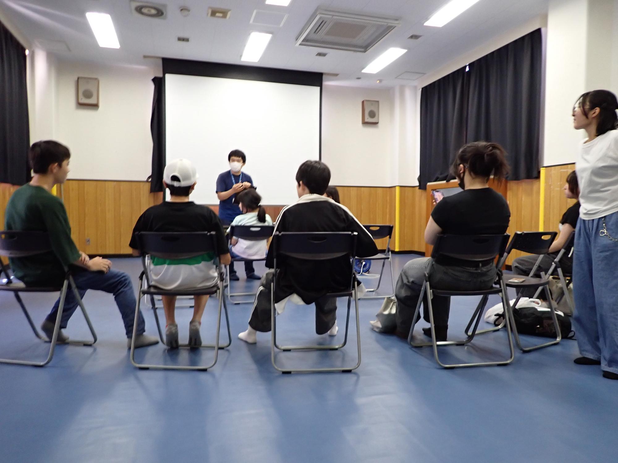 職員から行事の説明を受ける参加者の写真