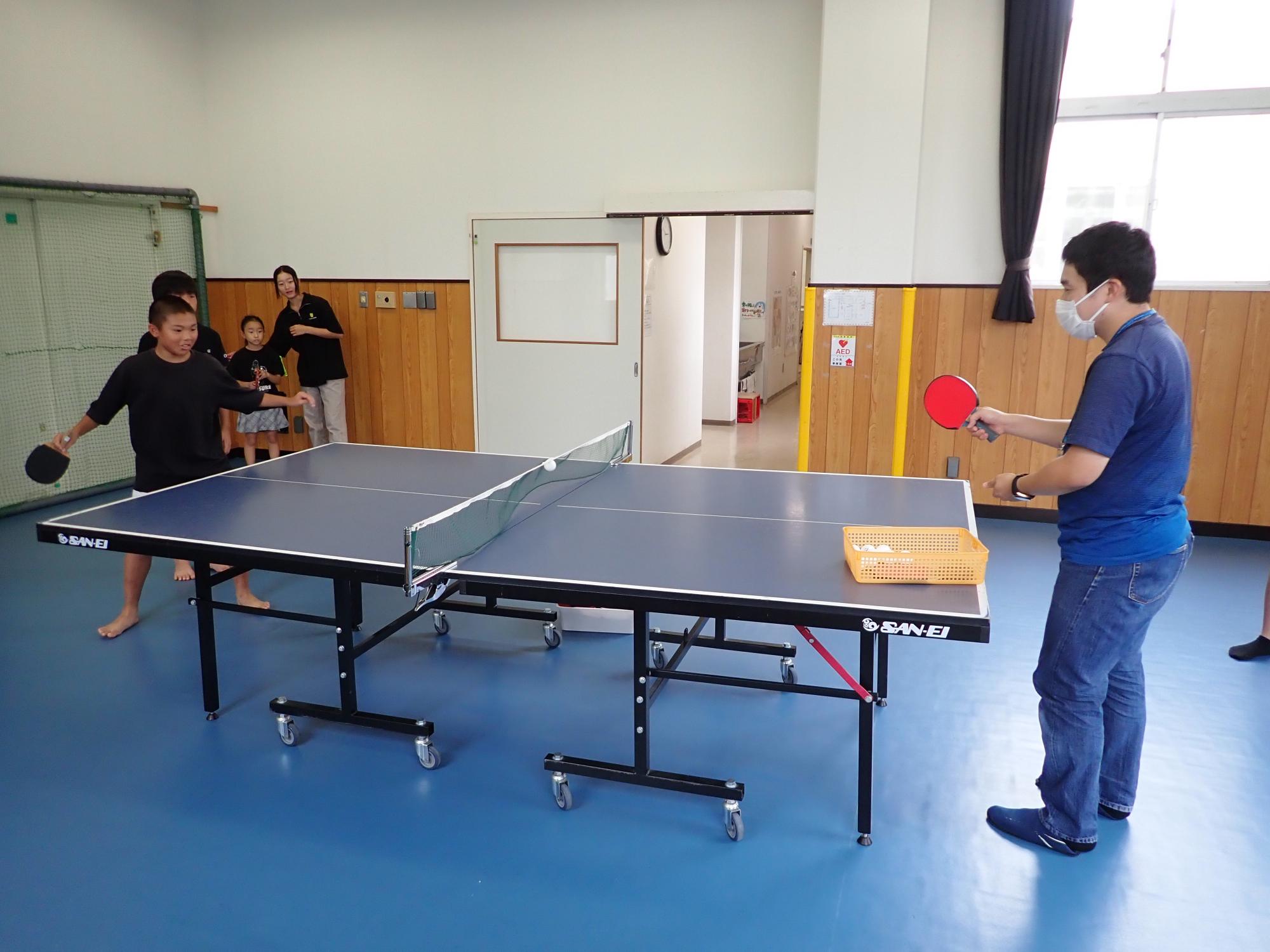 サーブを打つも失敗する職員の写真