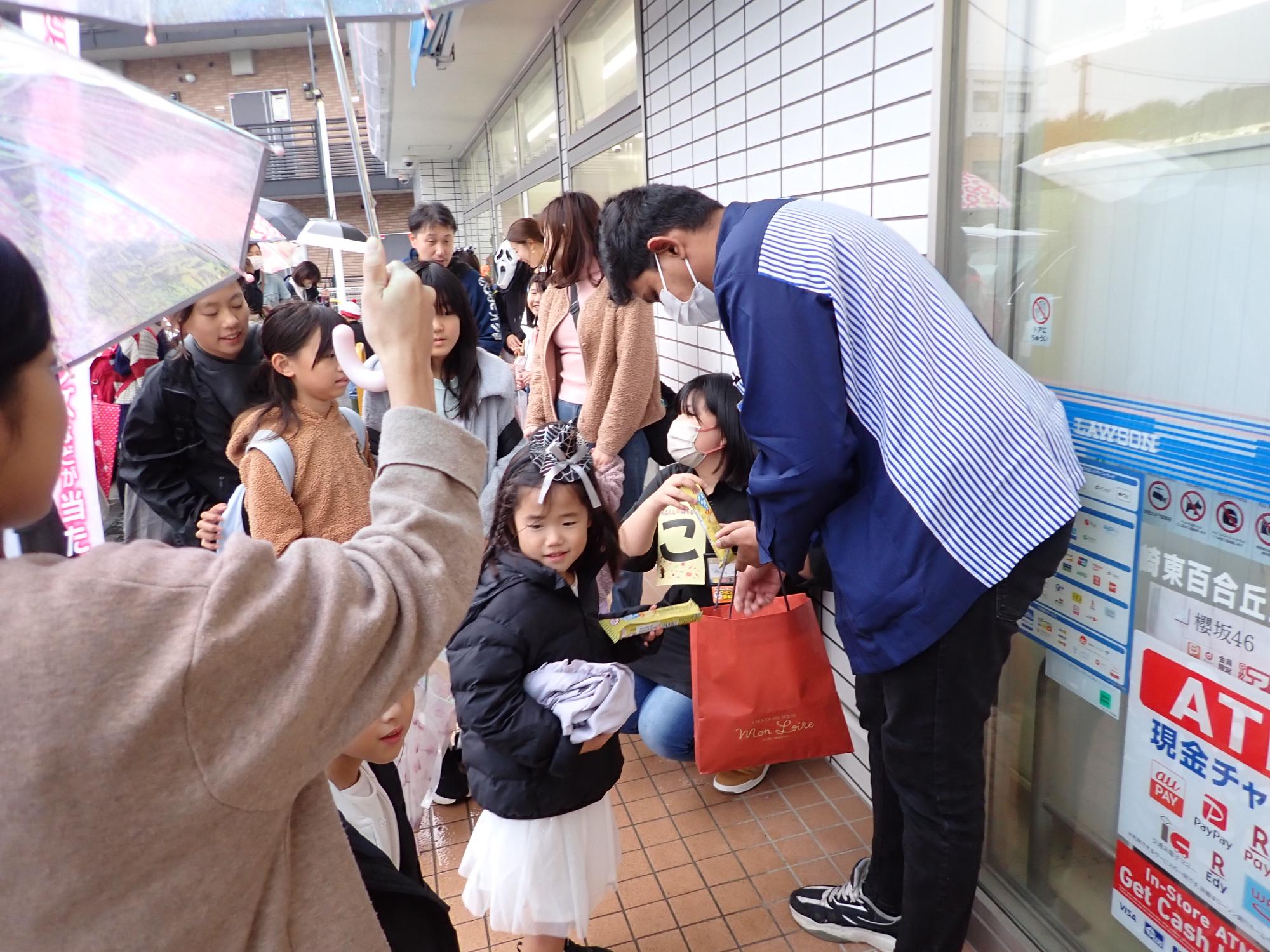 ローソンでお菓子をくれた店長さんとお菓子を貰う子ども達の写真