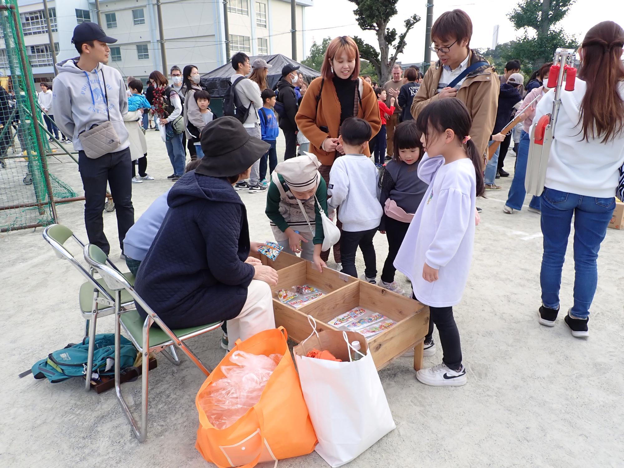 射的を終えて景品ブースで景品を選ぶ子ども達の写真