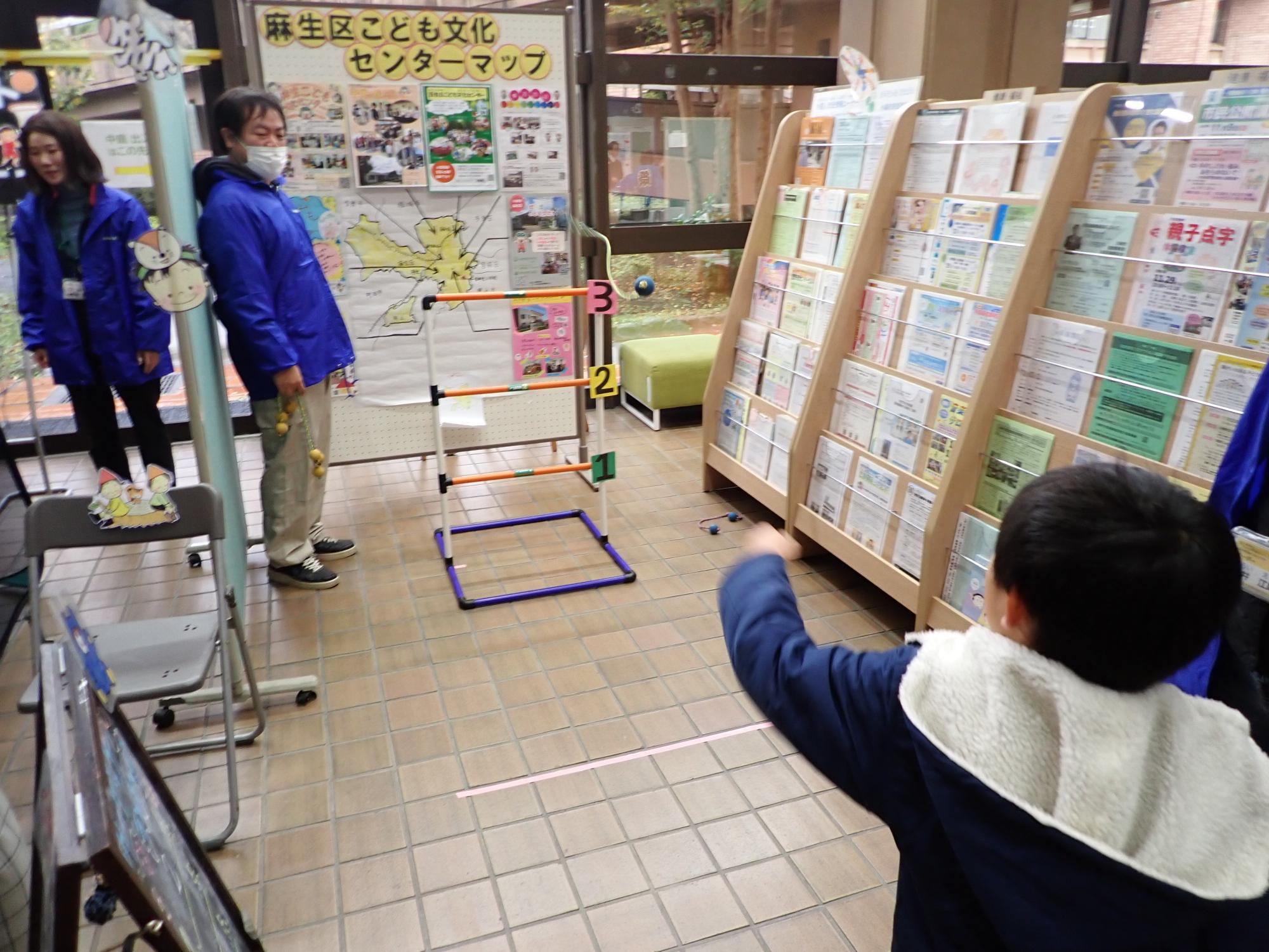 ラダーゲッターをする子どもと、その補助を行なう職員の写真