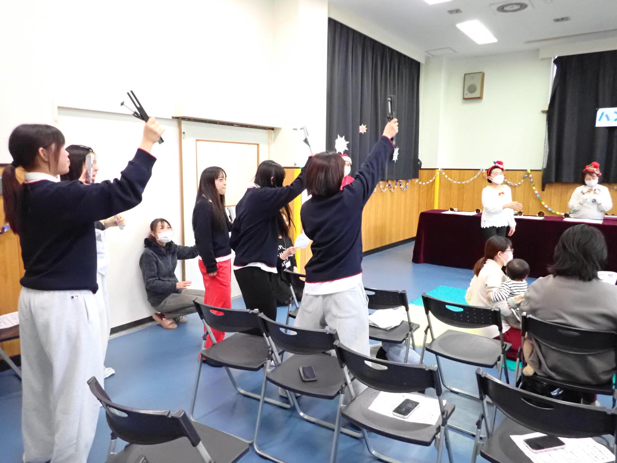 高校生も一緒にハンドベルを奏でている写真