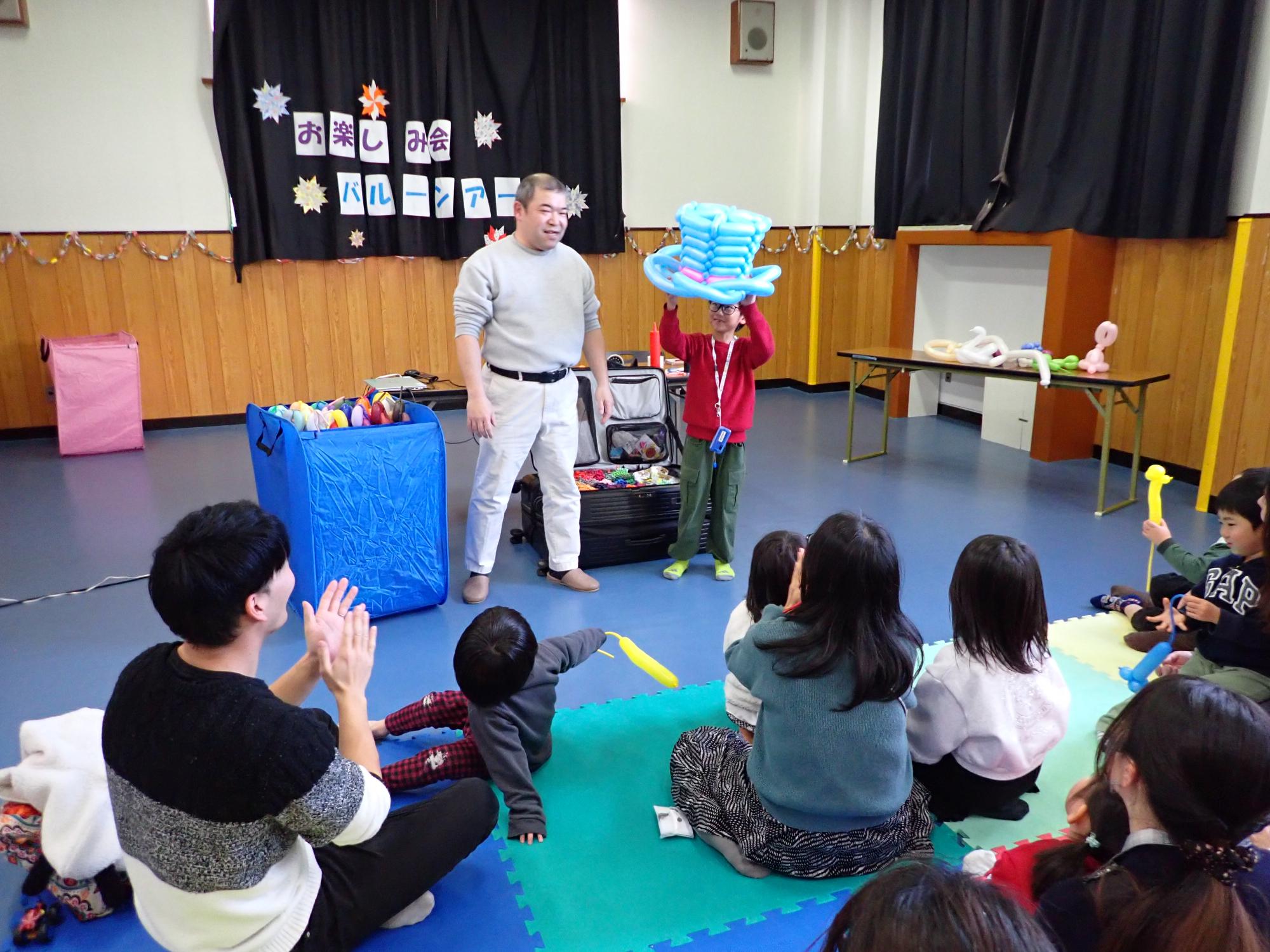 じゃんけんに勝ち残り見事1位をとった子が帽子の景品を手にした様子