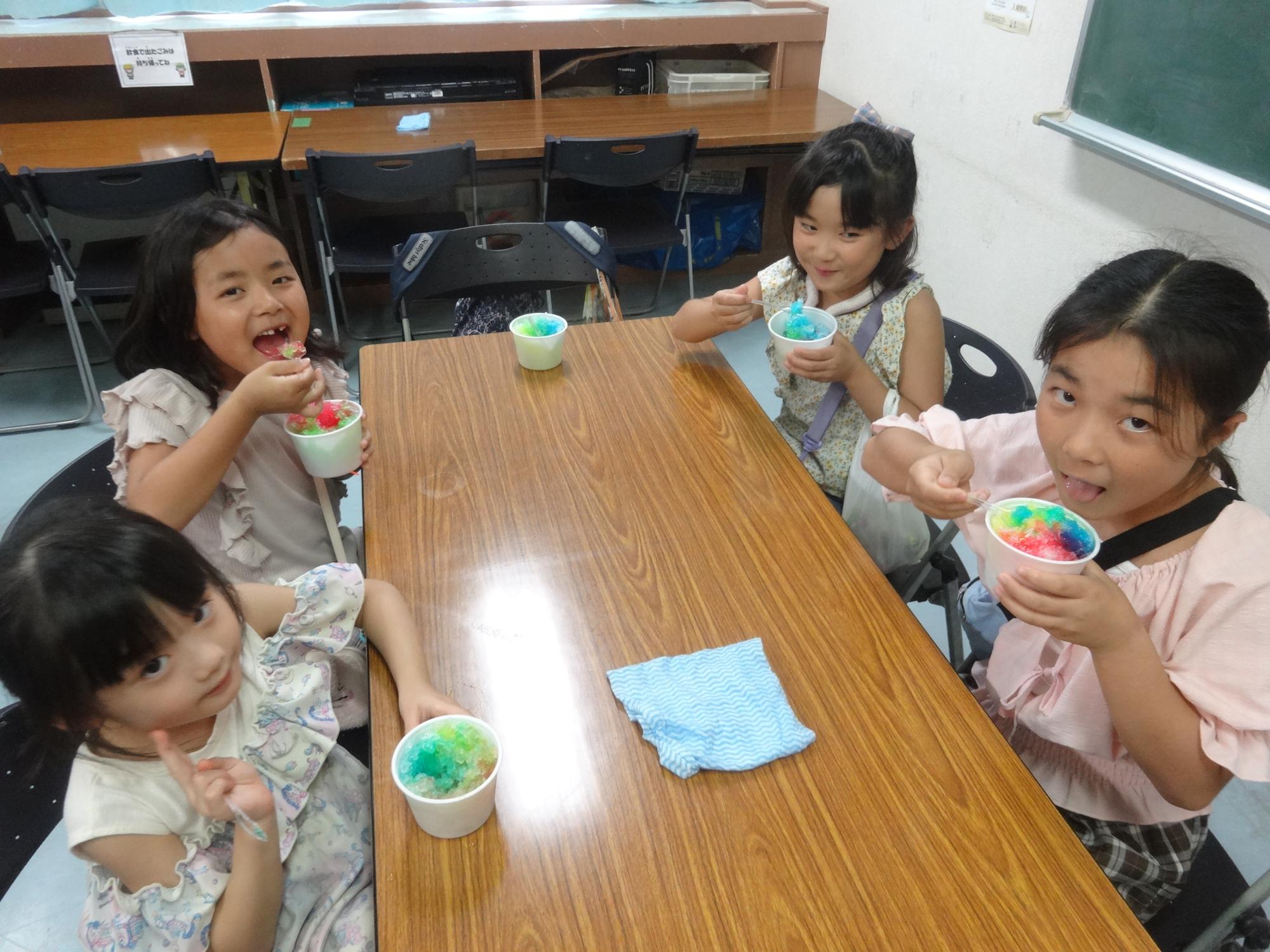 カラフルなかき氷を食べる小学生たちの写真