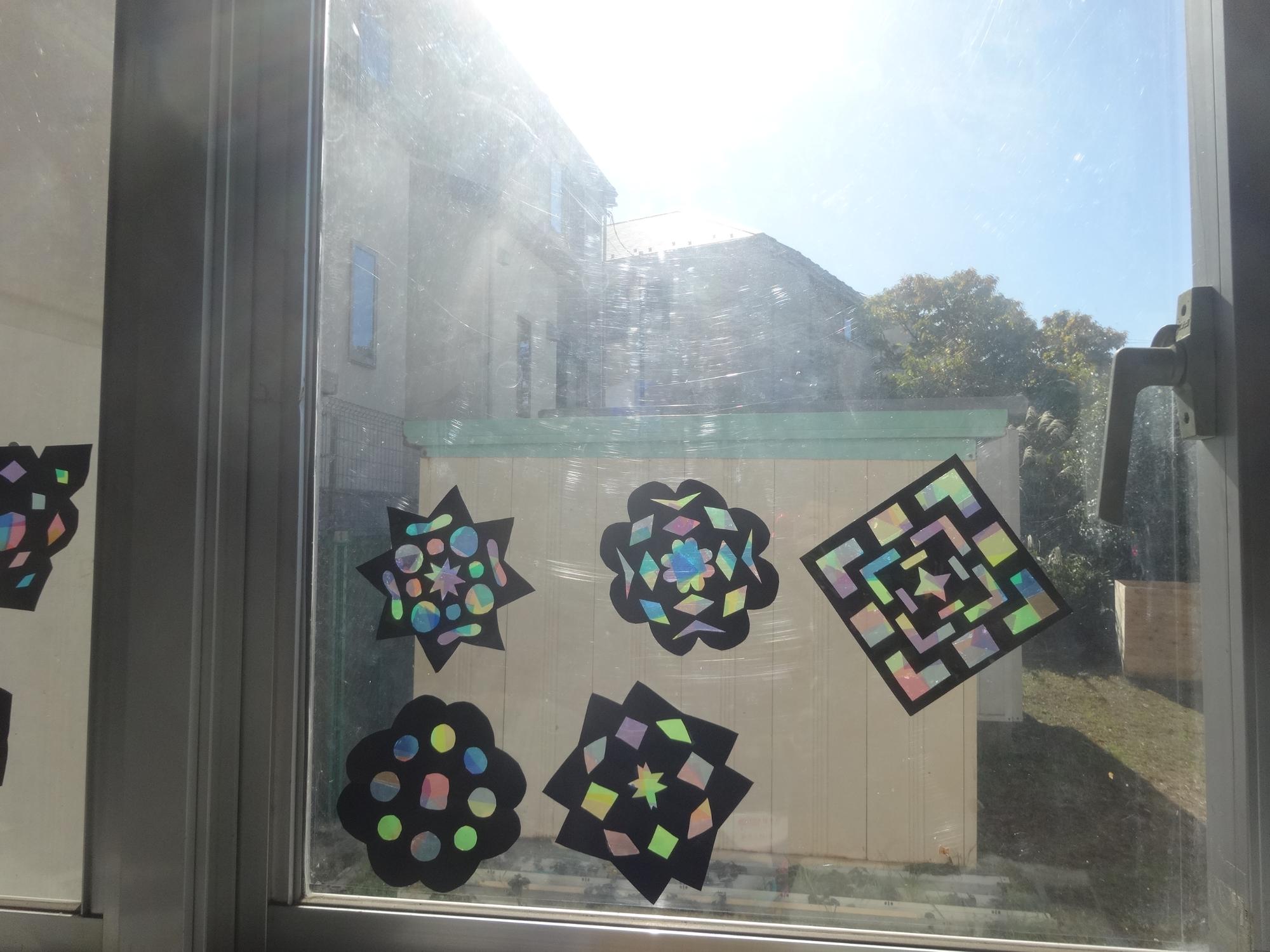 完成したステンドグラスを窓に貼って光を透かしている写真