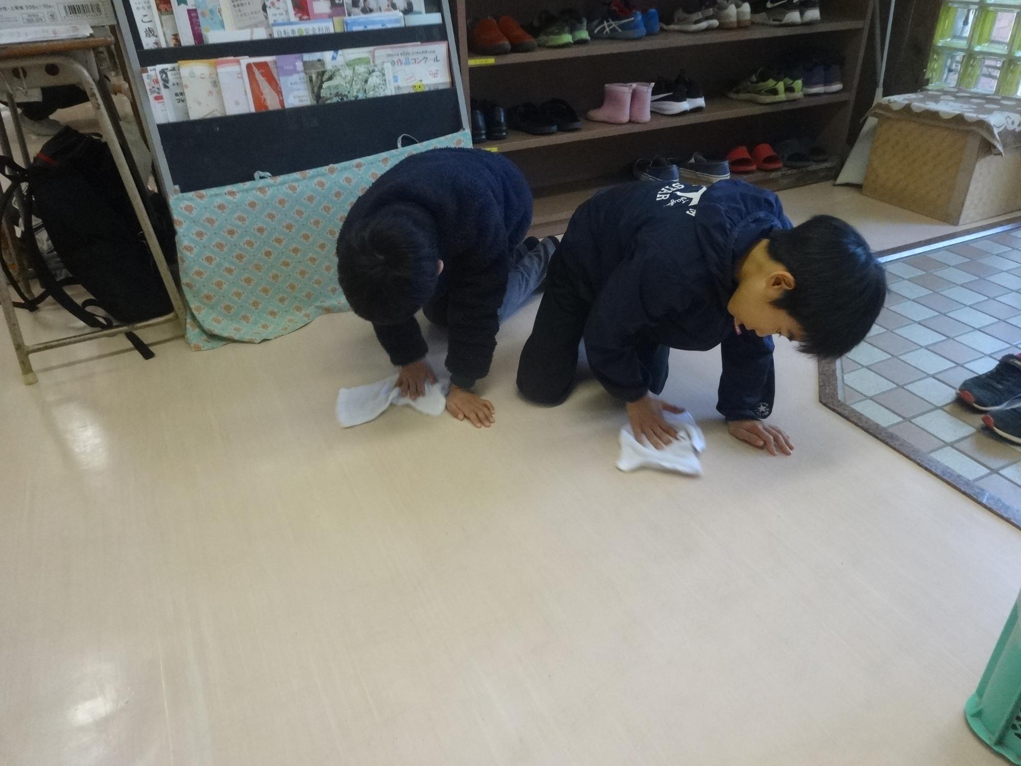 こども文化センターの玄関の床を磨く二人の小学生