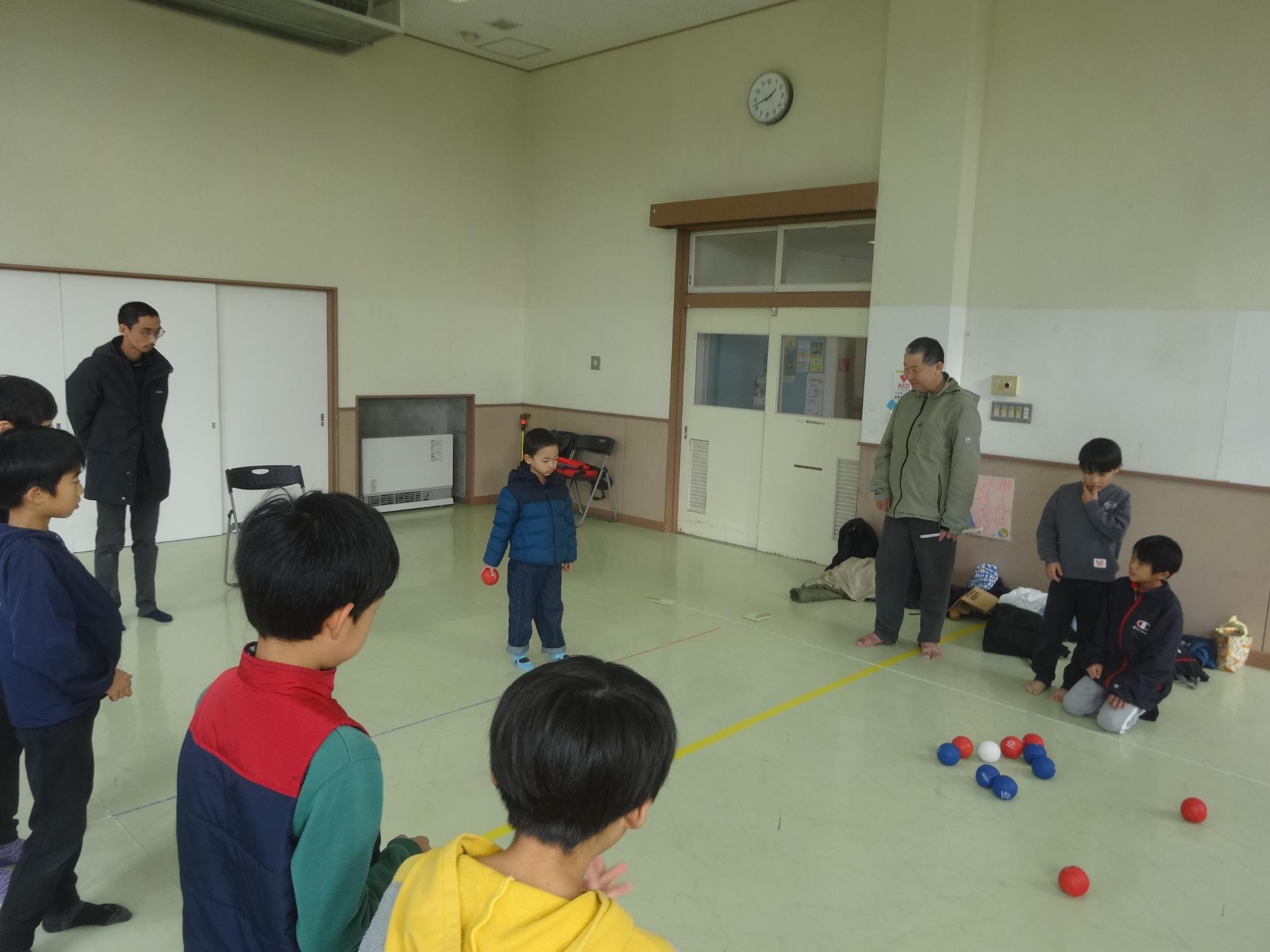 赤いボールを投げようとしている幼児