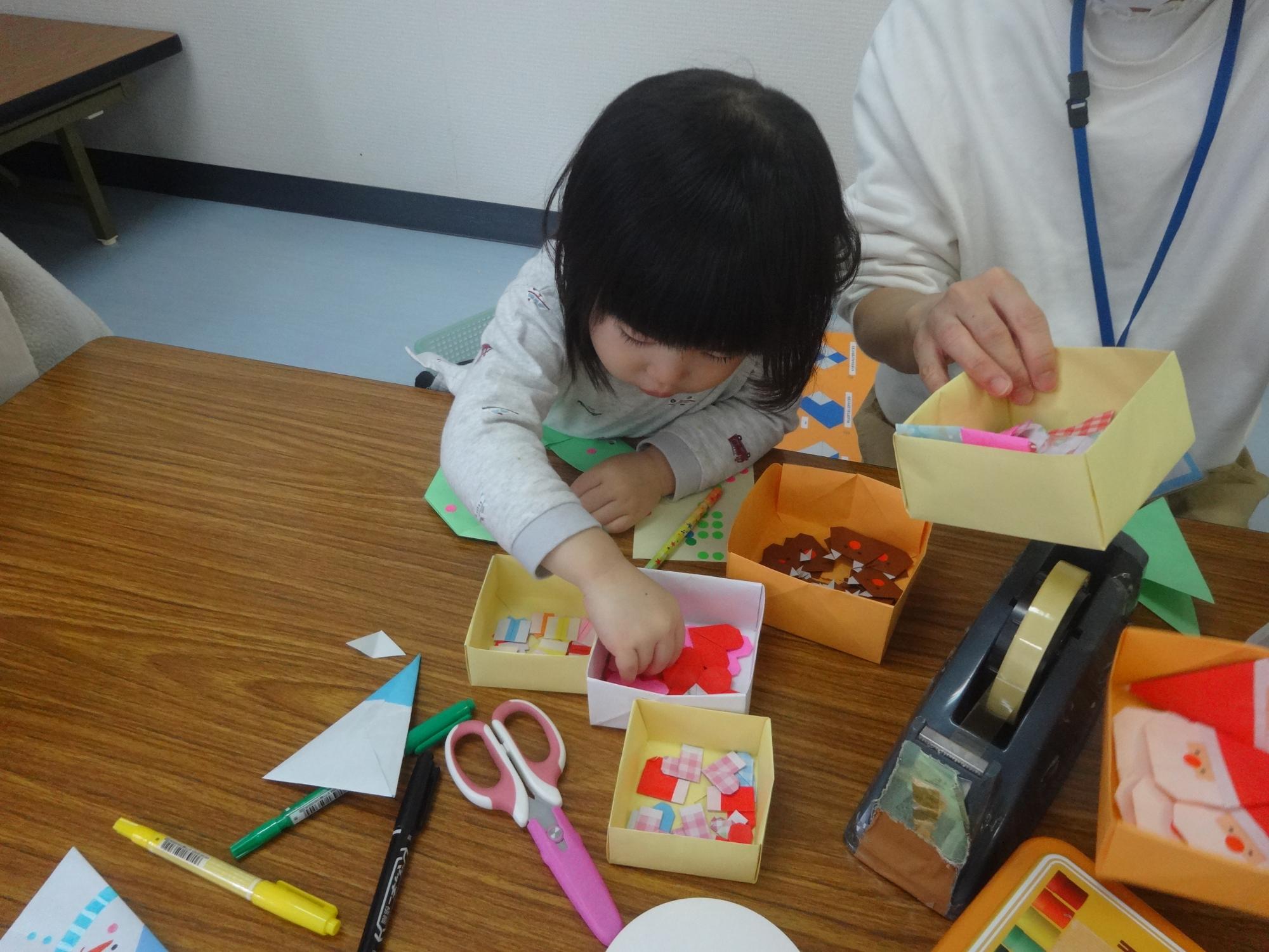 クリスマスリースを作る幼児