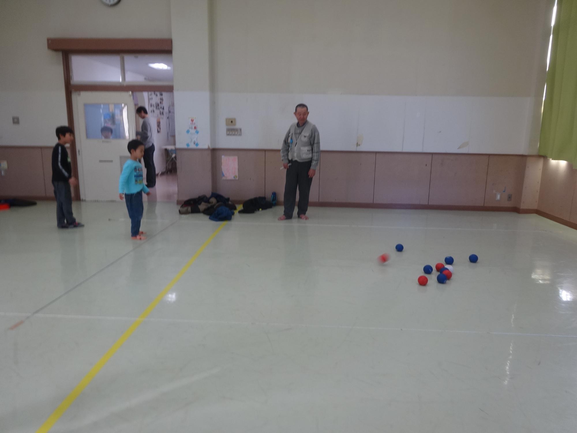 幼児がボールを投げてジャックボールの近くに落ちた写真