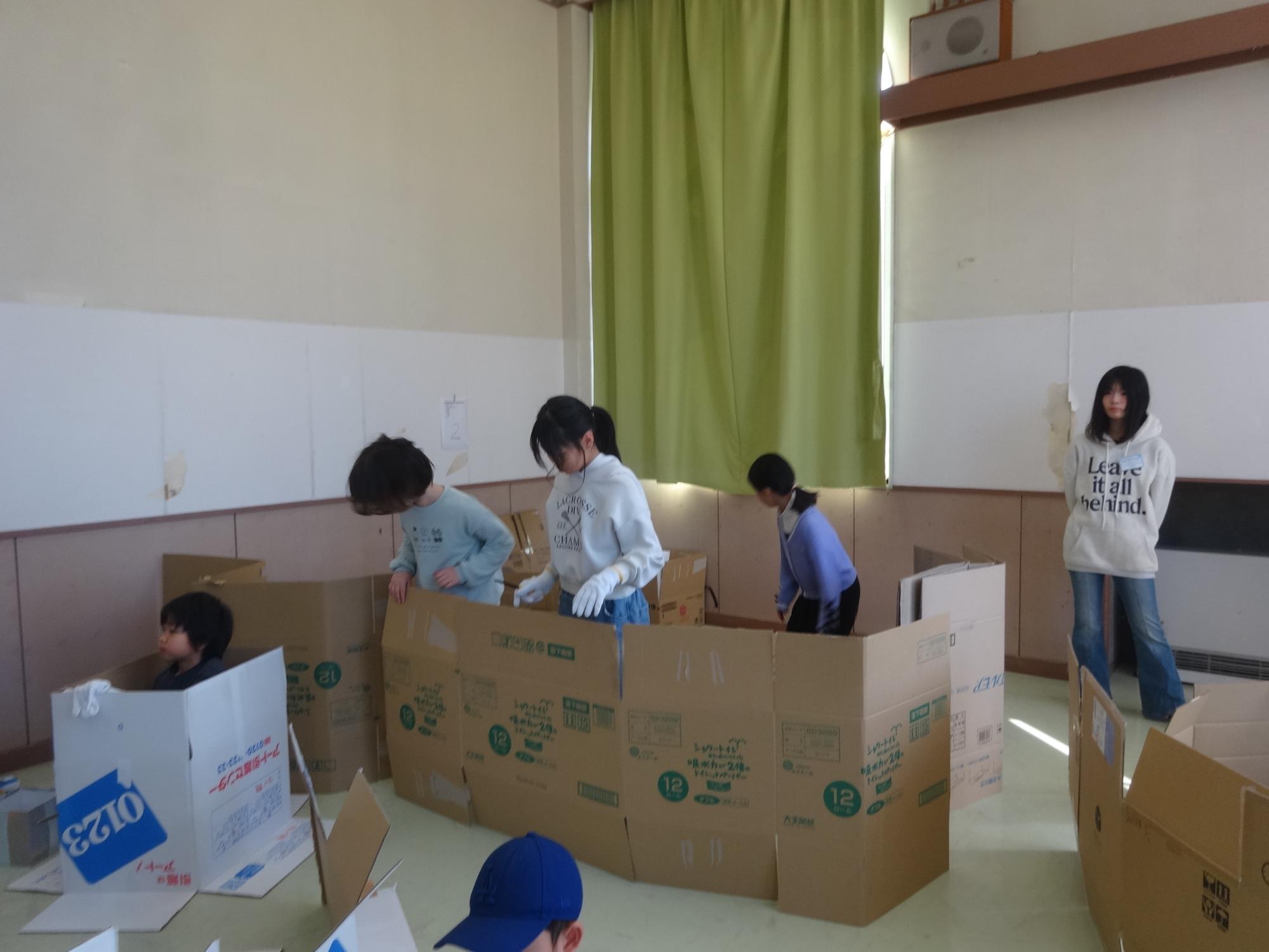 ダンボールハウスを作る子ども達の写真