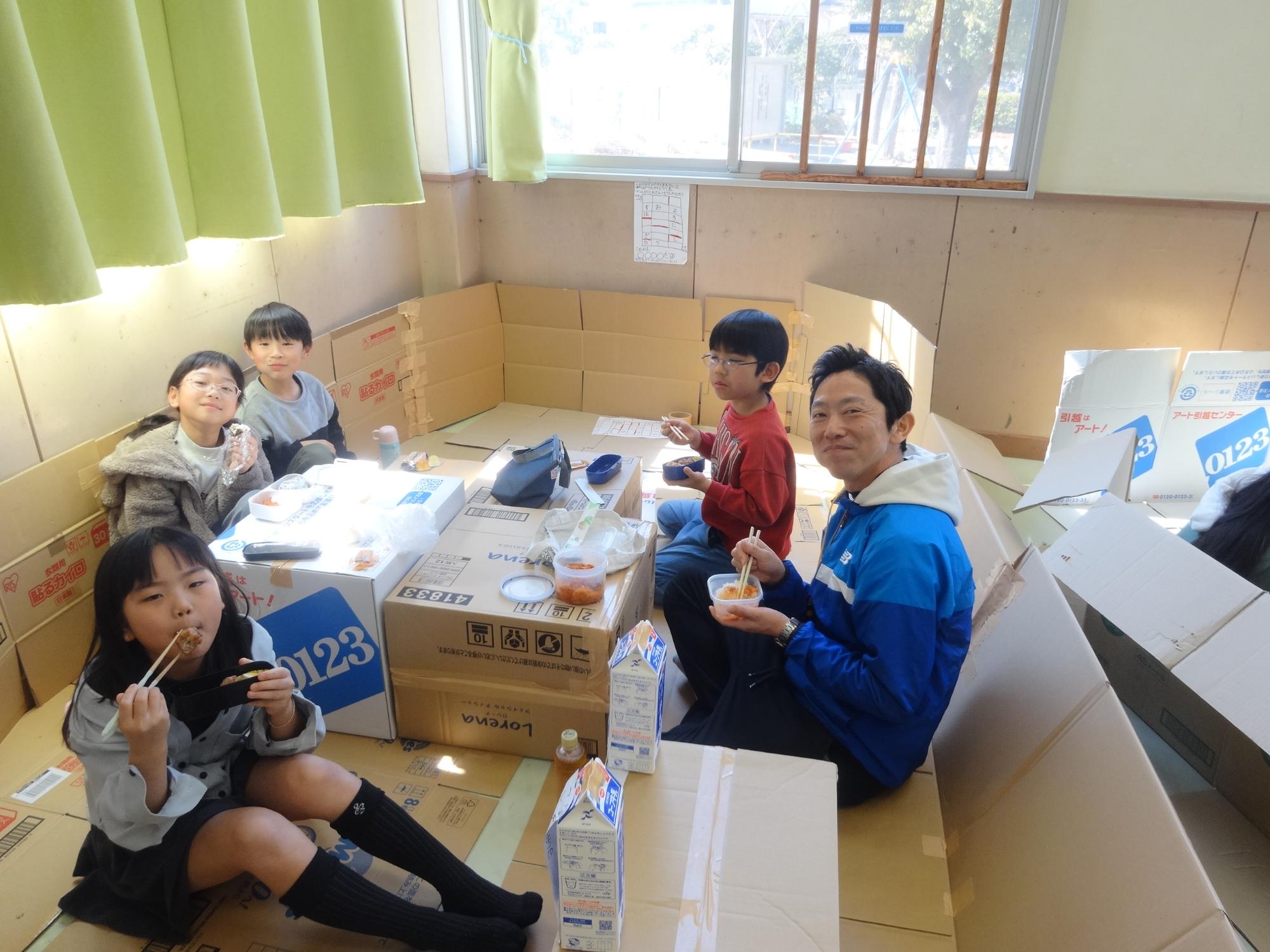 完成したハウスの中でお弁当を食べる子どもたちの写真