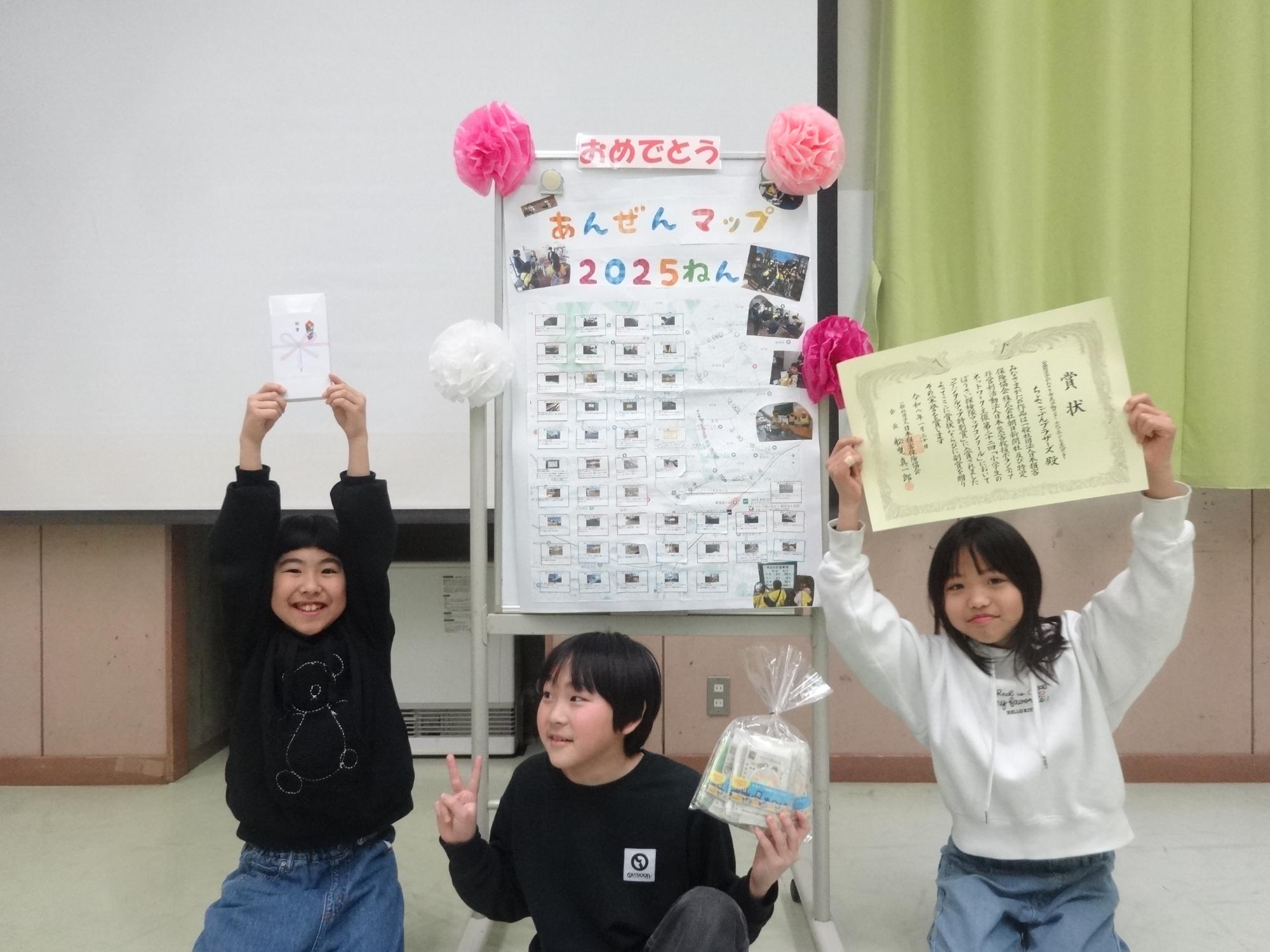 3人で作った地図をバックにピースサインをするちよこぶんブラザーズの3人