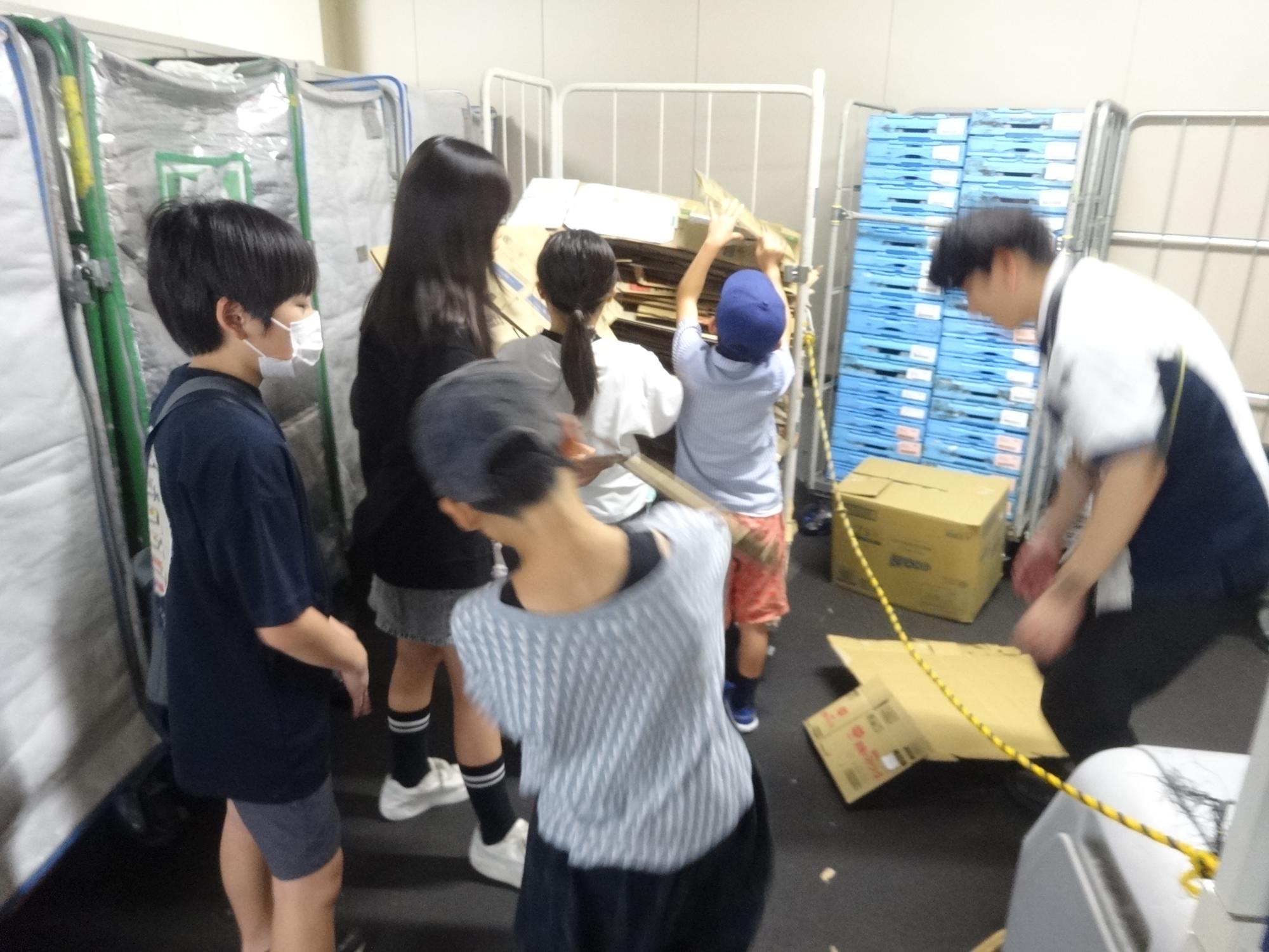 近隣の店舗の倉庫にてダンボールを子どもたちが貰っている写真
