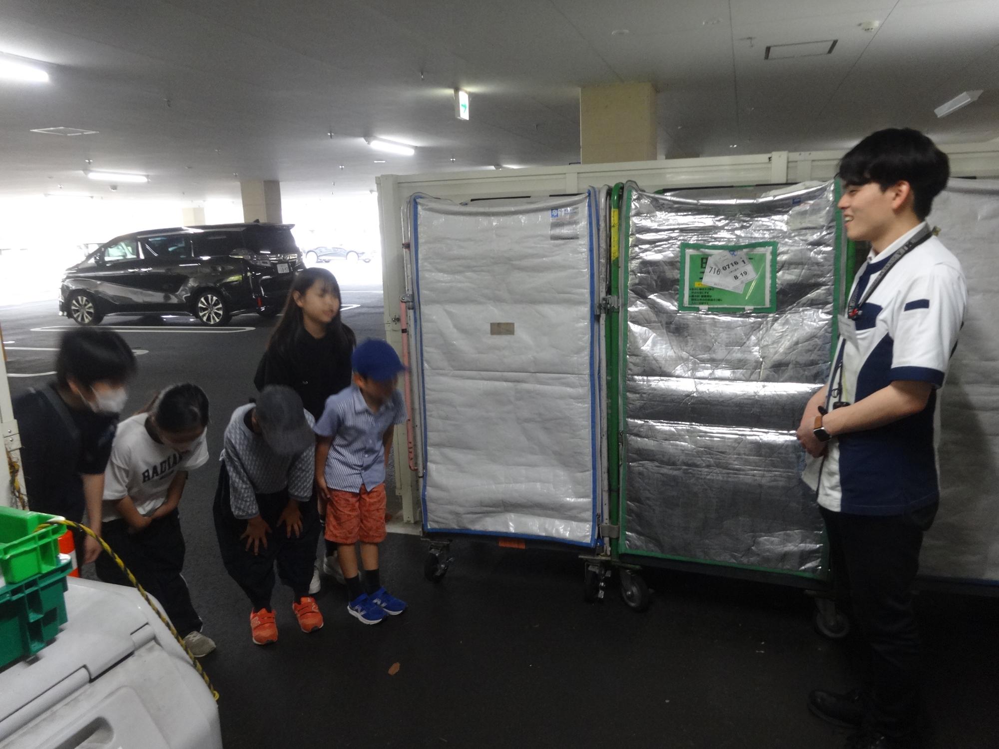 ご協力いただいた近隣店舗の方にお礼のあいさつをする小学生5人の写真