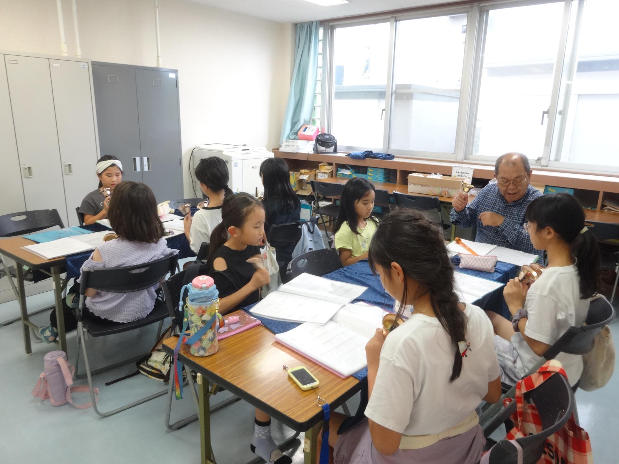 ハンドベルの練習をする8人の小学生