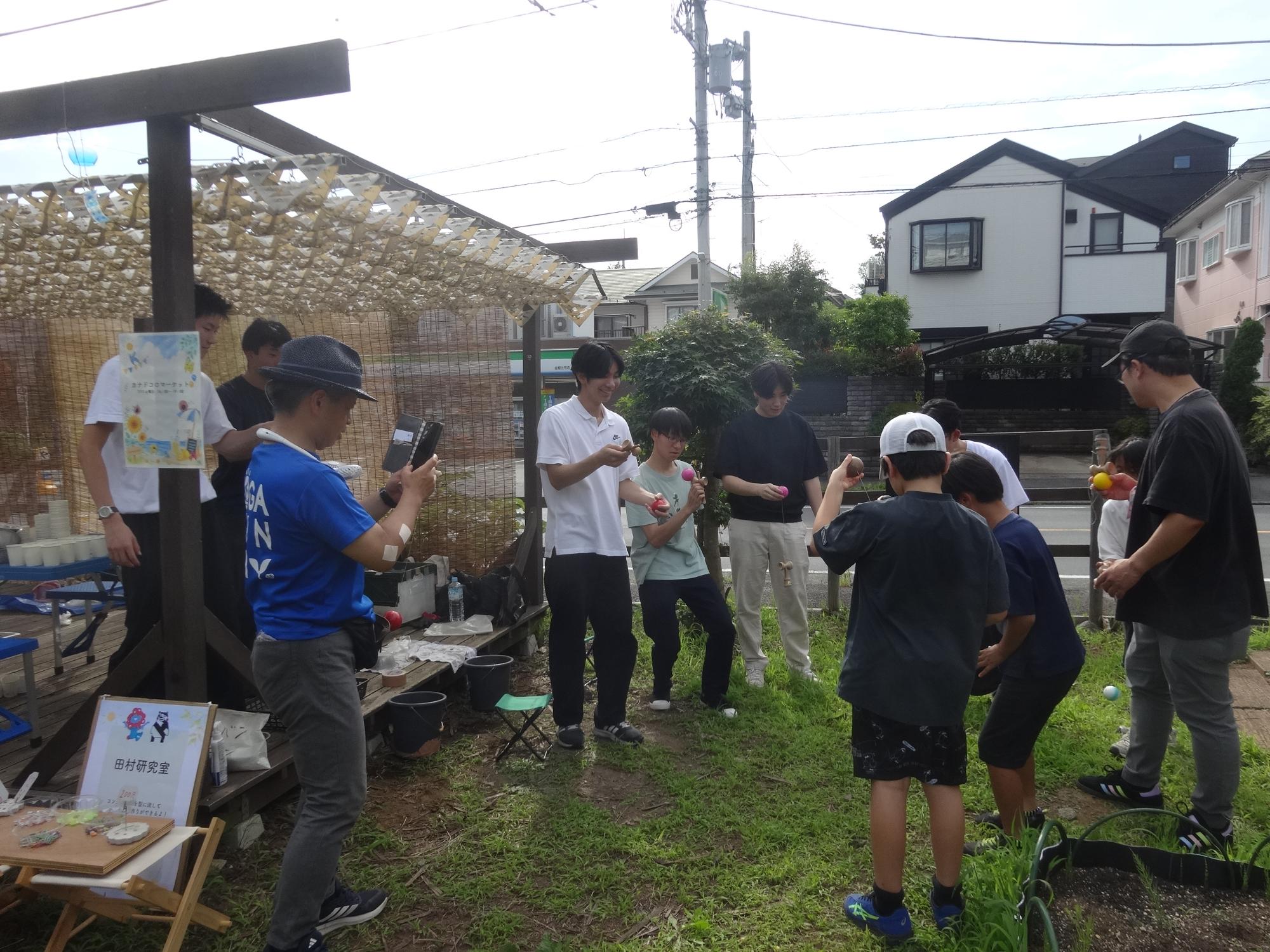 カナドコロスタッフの大学生とけん玉交流をするけん玉キッズたち
