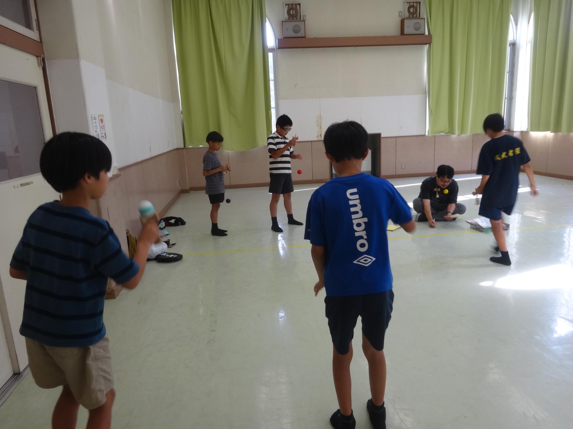検定の順番を待つ間にけん玉の練習をする4人の小学生