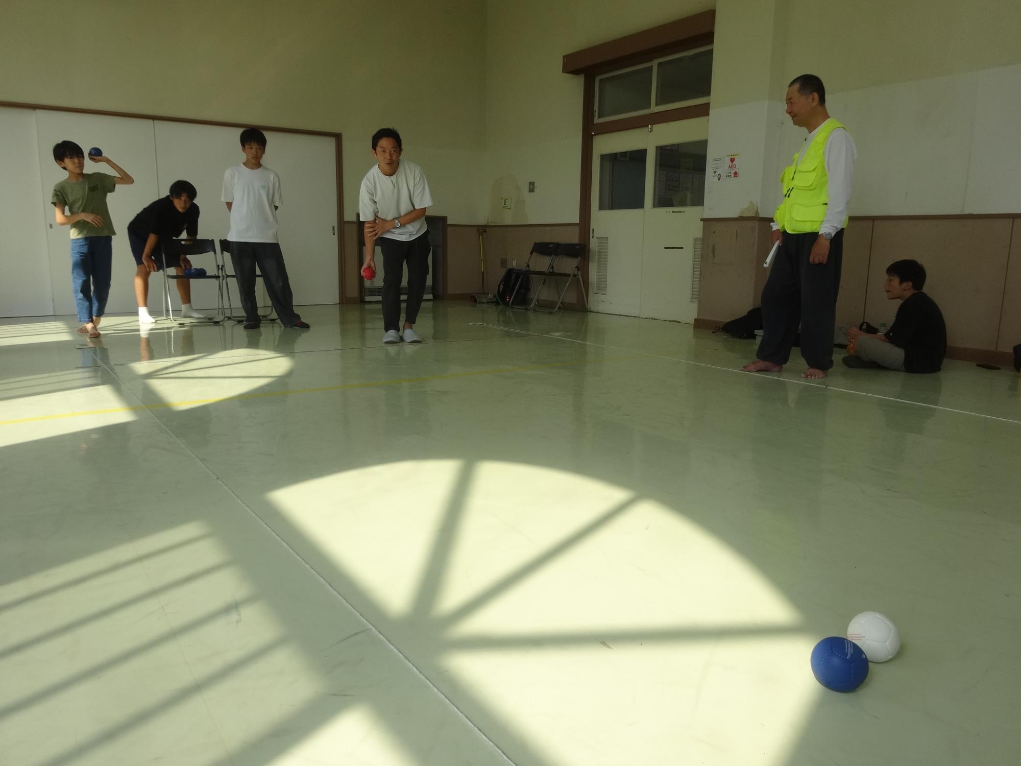 ボールを投げるスタッフを見守る中学生たち