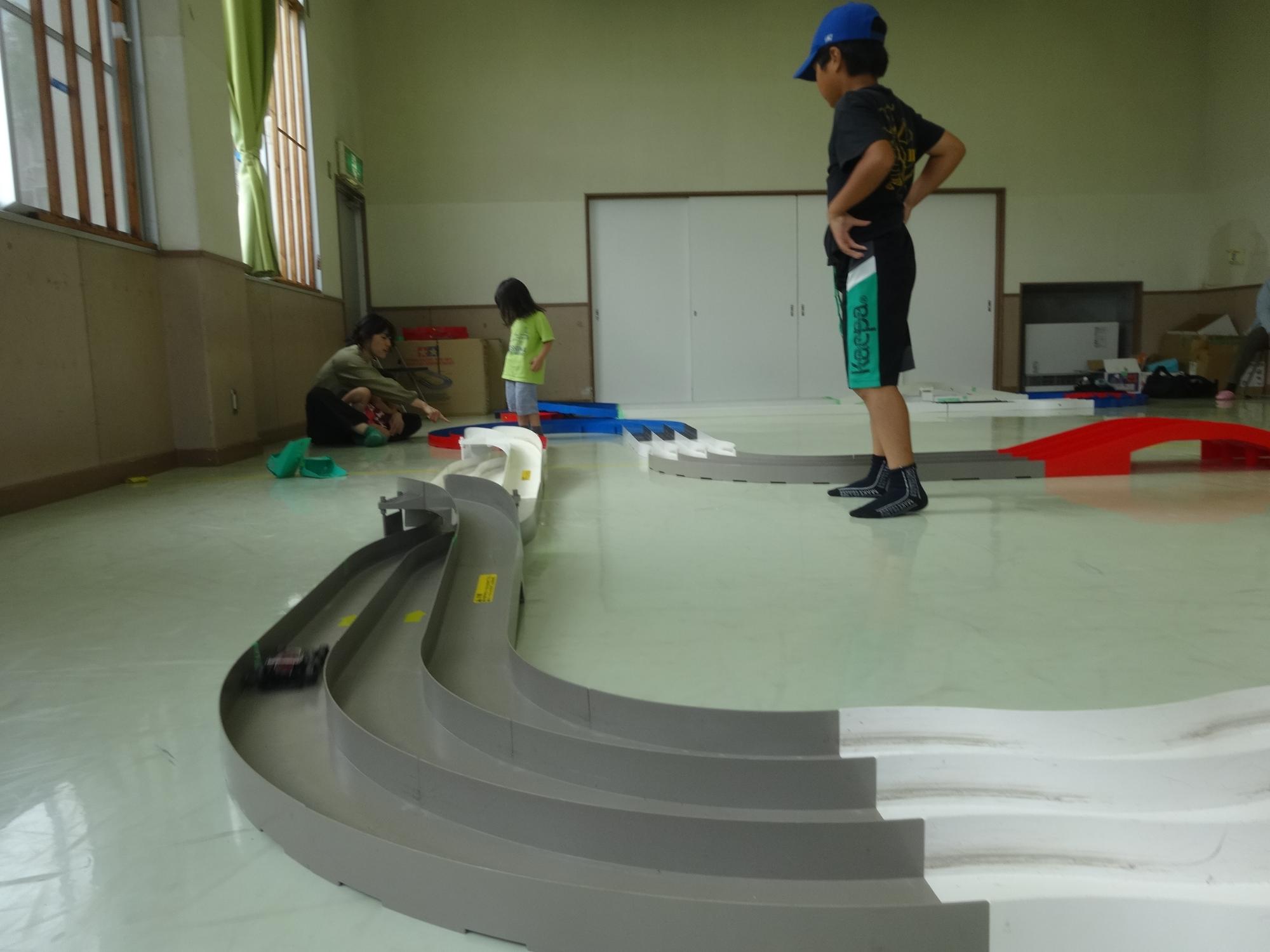 ミニ四駆が走る様子を見る子どもたち